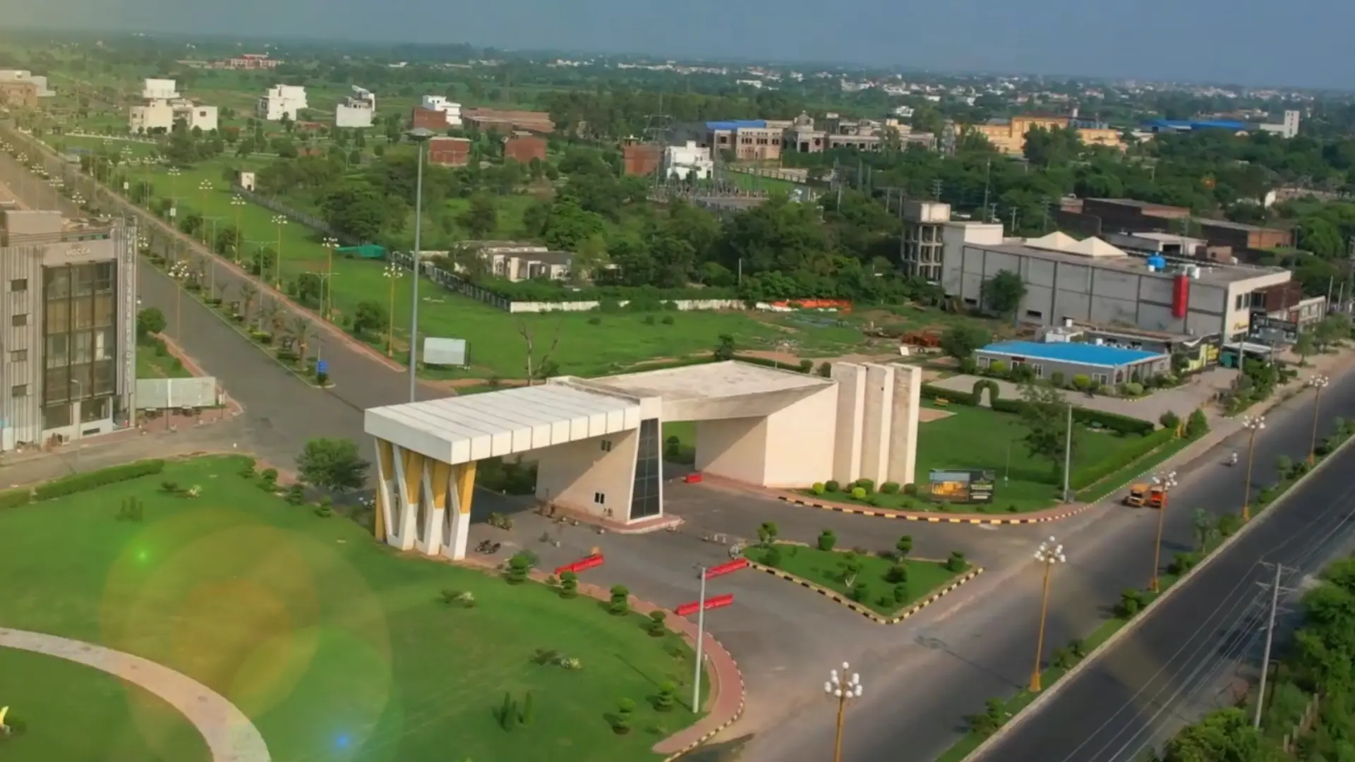 Golden-hour aerial view of a modern residential community boulevard lined with premium houses